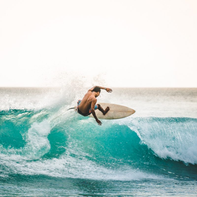 Professional,Surfer,Riding,Waves,In,Bali,,Indonesia.,Men,Catching,Waves